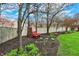 Landscaped backyard featuring a pair of red Adirondack chairs, garden beds, and a privacy fence at 9319 Oak Knoll Ln, Fishers, IN 46037