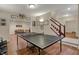 Recreation room with ping pong table, wood floors, and open to living room and stairs at 9319 Oak Knoll Ln, Fishers, IN 46037