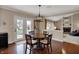 A dining area features a dark wood table and chairs with a view of the backyard and living room at 9319 Oak Knoll Ln, Fishers, IN 46037