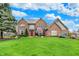 Beautiful brick two-story home with a well-manicured lawn and a bright red front door at 9319 Oak Knoll Ln, Fishers, IN 46037