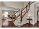 Elegant foyer features hardwood floors, a staircase with white rails, and a view into the living area at 9319 Oak Knoll Ln, Fishers, IN 46037