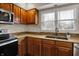 Kitchen featuring wood cabinets, granite countertops, double sink and a window at 9319 Oak Knoll Ln, Fishers, IN 46037