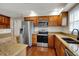 Modern kitchen with stainless steel appliances, granite countertops and wooden cabinetry at 9319 Oak Knoll Ln, Fishers, IN 46037