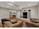 Basement living room with built-in shelves and media center, open to the rec room at 9319 Oak Knoll Ln, Fishers, IN 46037