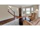 Elegant living room with hardwood floors, a staircase, and a view of the front yard at 9319 Oak Knoll Ln, Fishers, IN 46037
