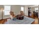Inviting living room with hardwood floors, two wingback chairs, and a view to the dining room at 9319 Oak Knoll Ln, Fishers, IN 46037