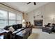 A comfortable living room features a fireplace, ceiling fan, and large windows at 9319 Oak Knoll Ln, Fishers, IN 46037