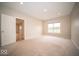 An empty bedroom featuring neutral carpet and an adjoining room through an open doorway at 9455 Orchard Cove Dr, Indianapolis, IN 46239