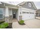 Charming home exterior showcasing a two-car garage and decorative stone accents at 9455 Orchard Cove Dr, Indianapolis, IN 46239