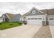Home with a two-car garage, inviting curb appeal with lush green lawn and young tree at 9455 Orchard Cove Dr, Indianapolis, IN 46239