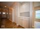 Inviting hallway featuring gleaming hardwood floors and modern white cabinets at 9455 Orchard Cove Dr, Indianapolis, IN 46239