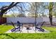 Serene backyard featuring a modern fire pit, stylish Adirondack chairs, and lush green lawn at 9944 Holaday Dr, Carmel, IN 46032