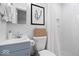 Stylish bathroom with a blue vanity, woven basket, botanical wall art, and shower at 9944 Holaday Dr, Carmel, IN 46032