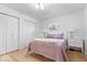 Bright bedroom with white walls, wood floors, and a cozy pink quilted bed at 9944 Holaday Dr, Carmel, IN 46032