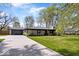 Lovely single story home with a long driveway, well-manicured lawn, and mature shade trees at 9944 Holaday Dr, Carmel, IN 46032