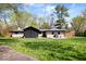Well-maintained home exterior featuring a screened-in porch, stone accents, and a spacious green lawn at 9944 Holaday Dr, Carmel, IN 46032