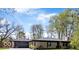 Charming ranch home featuring a stone facade, attached garage and inviting landscaping at 9944 Holaday Dr, Carmel, IN 46032