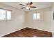 Bedroom features hardwood floors, a ceiling fan, and natural light from two windows at 1043 E Castle Ave, Indianapolis, IN 46227
