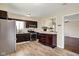 Open kitchen with stainless steel appliances, dark brown cabinetry, and tile floors at 1043 E Castle Ave, Indianapolis, IN 46227