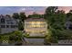 Impressive multi-level home with lake views and manicured landscaping, lit up at dusk at 10919 Brigantine Dr, Indianapolis, IN 46256