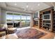 Cozy living room with a fireplace, built in shelves, and large sliding doors leading to a water view terrace at 10919 Brigantine Dr, Indianapolis, IN 46256