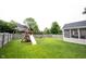 Large, well-maintained backyard with lush lawn, wooden fence, playset, and screened-in porch, perfect for outdoor enjoyment at 10982 Gate Cir, Fishers, IN 46038