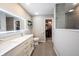 Modern bathroom featuring dual sinks, tile floors, a walk-in closet, and a sleek, lighted mirror at 10982 Gate Cir, Fishers, IN 46038