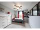 Cozy bedroom featuring neutral walls, comfortable bed, ceiling fan, and shelving units at 10982 Gate Cir, Fishers, IN 46038