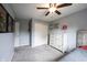 Bright bedroom with gray walls and carpet featuring a ceiling fan and closet, with additional wall-mounted shelves at 10982 Gate Cir, Fishers, IN 46038