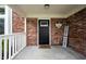 Close-up of the welcoming front porch with brick accents and a stylish black door at 10982 Gate Cir, Fishers, IN 46038