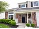 Inviting front porch with brick facade, decorative columns, and a black front door at 10982 Gate Cir, Fishers, IN 46038