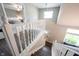 Hallway with hardwood floors, white railing, and bedroom entryway with ceiling fan at 10982 Gate Cir, Fishers, IN 46038