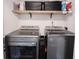 Well-organized laundry room with grey machines and open wooden shelf space for storage baskets at 10982 Gate Cir, Fishers, IN 46038