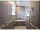 Tiled walk-in shower featuring gray tiling, a built-in seat, and glass block window, creating a modern and relaxing experience at 10982 Gate Cir, Fishers, IN 46038