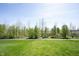 Lush green backyard with mature trees and a paved pathway in a serene setting at 11327 Guy St, Fishers, IN 46038