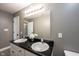 Bright bathroom featuring a double sink vanity with black countertop and white cabinets, plus a large mirror at 11327 Guy St, Fishers, IN 46038