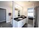 Bright bathroom showcasing a vanity with black countertop, white cabinets, and access to main bedroom at 11327 Guy St, Fishers, IN 46038