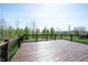 Spacious wooden deck with black railing, offering beautiful views of the surrounding greenery and blue sky at 11327 Guy St, Fishers, IN 46038