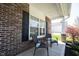 Close up of a front porch with brick columns and seating in front of a large window at 11327 Guy St, Fishers, IN 46038