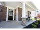 Charming front porch with brick columns, comfortable seating, and decorative landscaping at 11327 Guy St, Fishers, IN 46038