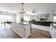 Open-concept living space featuring a kitchen island, dining area, and living room with a fireplace at 11327 Guy St, Fishers, IN 46038