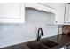 Close-up of kitchen sink with black faucet and marble-look tile backsplash at 11327 Guy St, Fishers, IN 46038