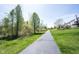 Paved path surrounded by trees and green grass, offering a peaceful walking experience near houses at 11327 Guy St, Fishers, IN 46038