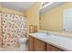 Bright bathroom featuring peach-themed shower curtain, wood cabinets and a large mirror at 11651 Beardsley Way, Fishers, IN 46038