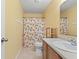 Bright bathroom with tiled floor, peach-themed shower curtain, wood cabinets, and a large mirror at 11651 Beardsley Way, Fishers, IN 46038