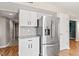 Well-lit kitchen with stainless steel refrigerator, white cabinets, granite counters and grey backsplash at 11651 Beardsley Way, Fishers, IN 46038