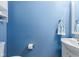 Cozy powder room featuring a blue wall, modern vanity and mirror, and practical fixtures at 11651 Beardsley Way, Fishers, IN 46038