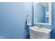 Serene powder room with a blue wall, classic vanity, and a neatly placed mirror at 11651 Beardsley Way, Fishers, IN 46038
