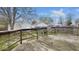View of wood deck and backyard including wooden fence, grass, and mature trees at 122 S 3Rd Ave, Beech Grove, IN 46107