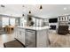 Open kitchen features a large island with seating, stainless steel dishwasher, and a view to the living room at 1242 Petit Verdot Dr, Westfield, IN 46074